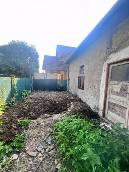 Starší rodinný dům v Brehoch, Nová Baňa, okres Žarnovica, s hliněným dvorem a vegetací.