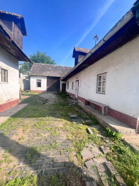 Dvůr rodinného domu v obci Brehy, Nová Baňa, okres Žarnovica, s travnatou cestou.