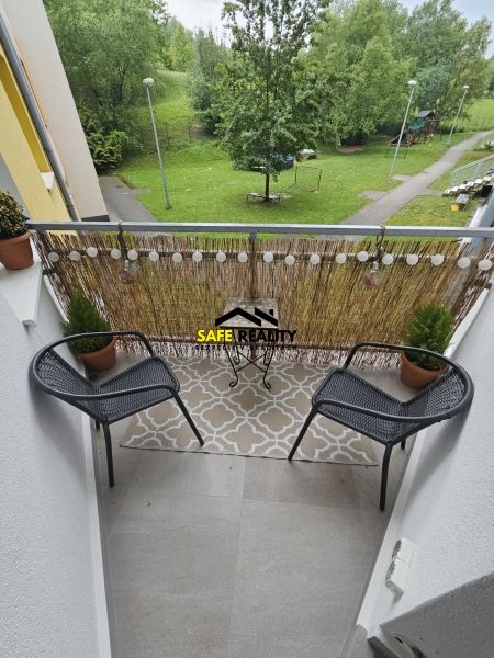 Balkon 3pokojového bytu nabízí výhled na zeleň a dětské hřiště.