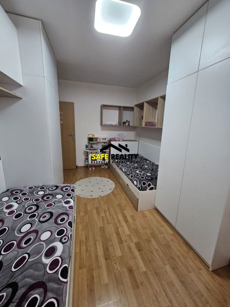 Dětský pokoj s postelemi a podlahou s dřevěným dekorem ve 3-pokojovém bytě.