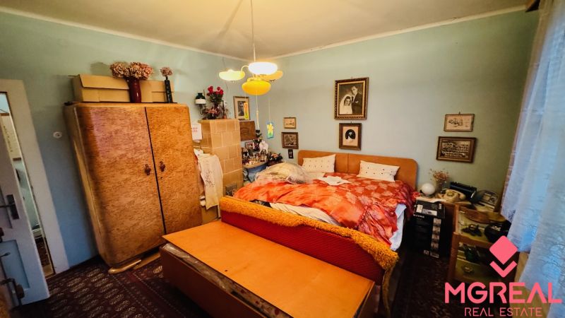 Ložnice v 3pokojovém bytě s vintage nábytkem a dekorací.