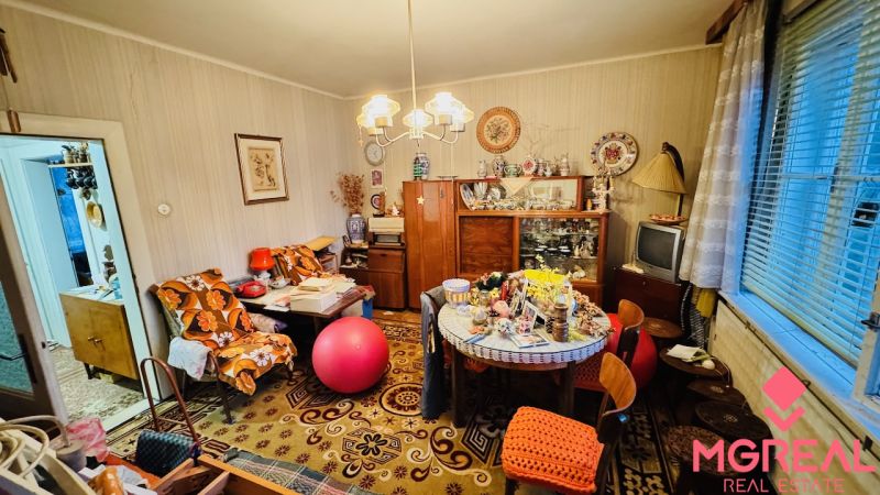 Pokoj plný vintage nábytku a dekorací ve 3-pokojovém bytě s podlahou s dřevěným dekorem.