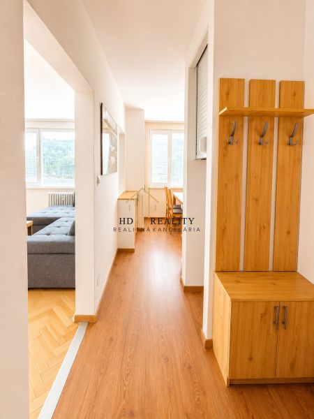 Útulná předsíň s chodbou a podlahou s dřevěným dekorem ve 2-pokojovém bytě.