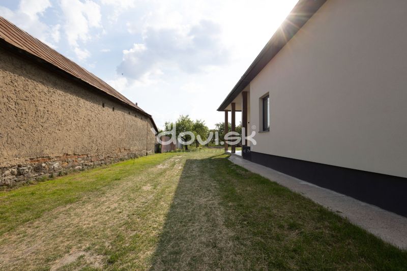 Pohled na dvůr rodinného domu v Zemplínské Široké s travnatým porostem.