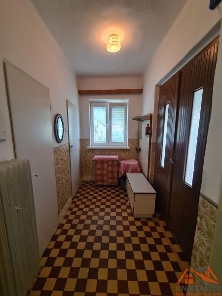 Chodba s dlažbou v rodinném domě, světelný zdroj, úložný prostor, radiátor.