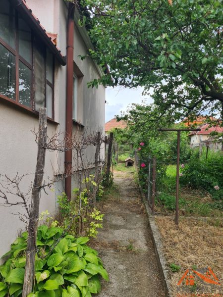 Zahrada vedle rodinného domu v Dulovcích s chodníkem a rostlinami.