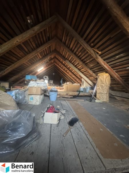 Podkroví rodinného domu zaplněné různými předměty, včetně kartonových krabic.