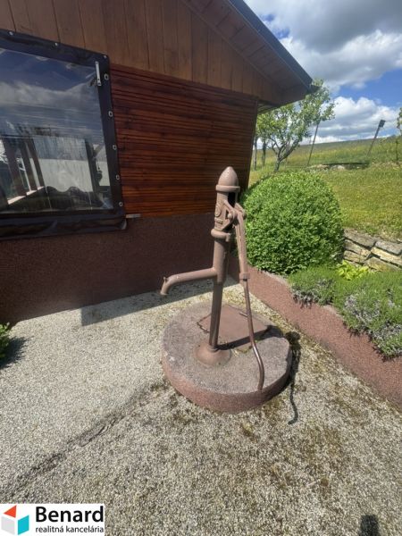 Rodinný dům v Orlové se starou vodní pumpou na štěrkovém podloží.