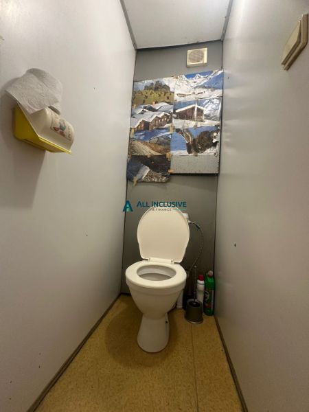 Toaleta se stěnovou dekorací a úložným prostorem ve 2pokojovém bytě.