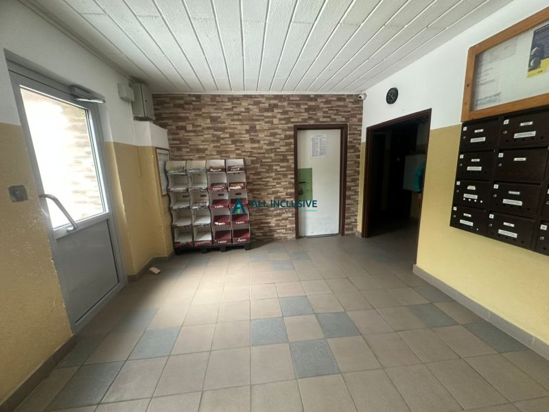 Vstupní chodba bytového domu s dlažbou a schránkami, ve 2-pokojovém bytě.