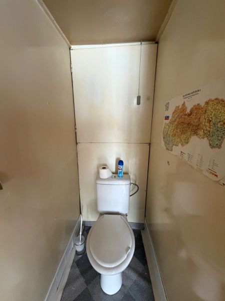 Úzká toaleta s mapou na stěně v 3-pokojovém bytě.