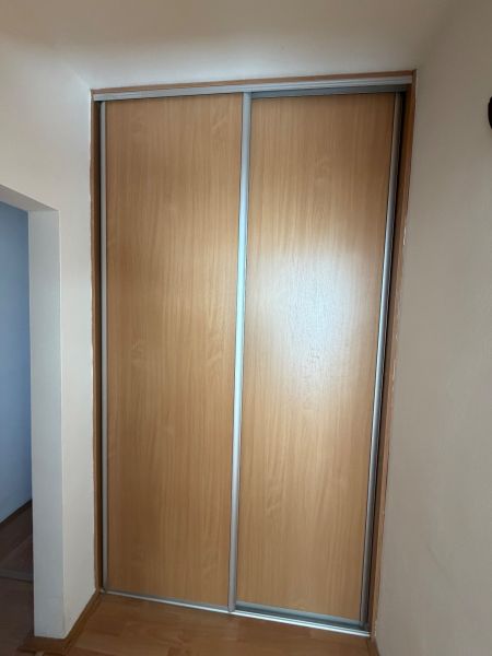 Skříň s posuvnými dveřmi a podlahou s dřevěným dekorem v 3-pokojovém bytě.