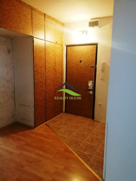 Vstupní chodba s podlahou s dřevěným dekorem v 3pokojovém bytě s šatníkovými skříněmi.