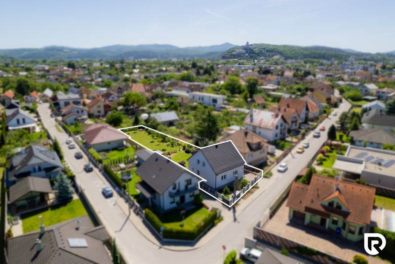 Rodinný dům na Jahodové ulici v Trenčíně, obklopený zelení a blízkými domy.