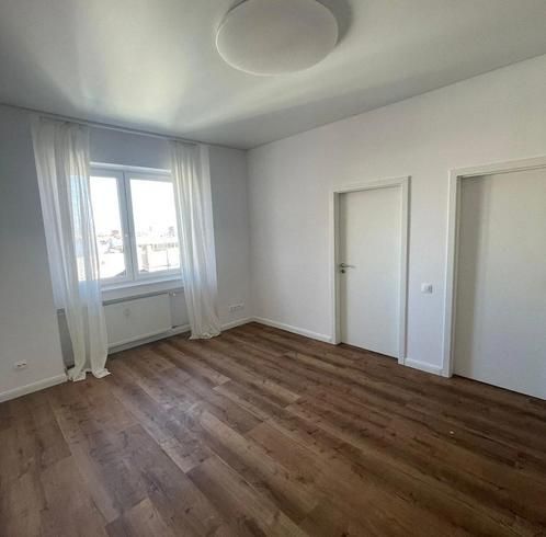 Pokoj s podlahou s dřevěným dekorem, bílými stěnami a závěsy v 3-pokojovém bytě.