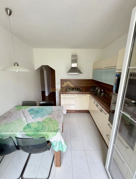 Kuchyně ve 4-pokojovém bytě s jídelním stolem a moderní linkou.
