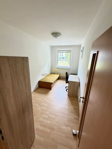 Jedna z zařízených místností ve 4pokojovém bytě s podlahou s dřevěným dekorem.