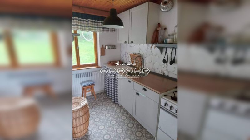 Kompaktní kuchyně v rodinném domě s retro dekorem a dřevěným stropem.