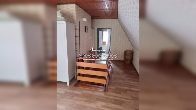 Podkrovní pokoj s podlahou s dřevěným dekorem v rodinném domě.