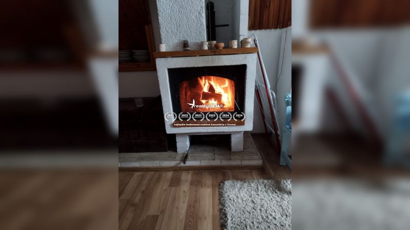 V rodinném domě se nachází krb na podlaze s dřevěným dekorem.
