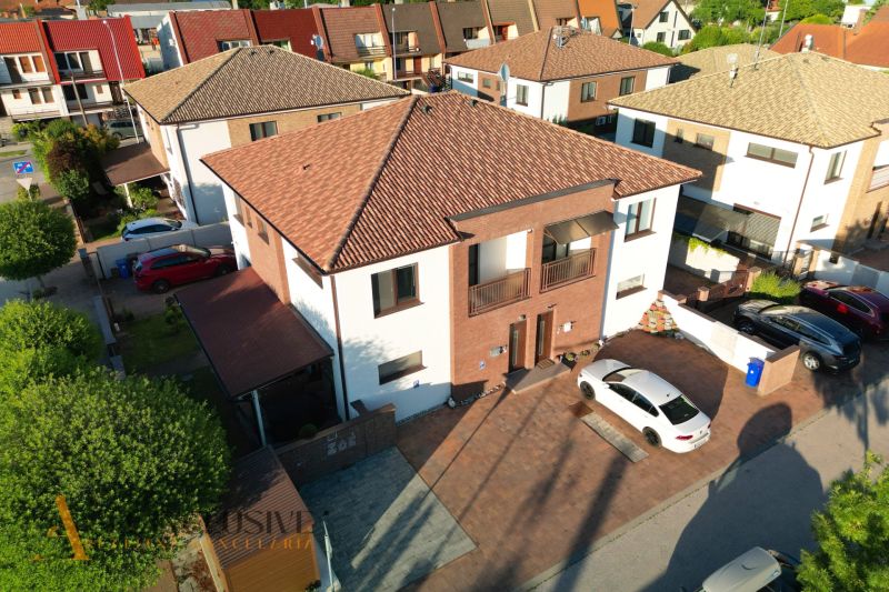 V Dunajské Stredě jsou zobrazeny moderní domy s parkovištěm před vchodem.