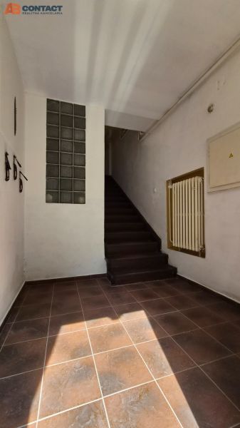 Chodba schodiště v 2-pokojovém bytě s keramickou dlažbou a schody.