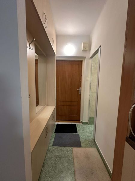 Vstupní chodba v rekreačním apartmánu se zabudovanými skříněmi a věšáky.