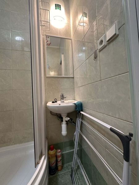 Koupelna Rekreačního apartmánu s umyvadlem, sprchou a sušákem na prádlo.