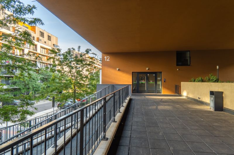Exteriér nemovitosti na ulici Zuzany Chalupové, Bratislava - Petržalka, u vchodu se závorou.