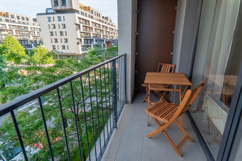 Balkon 1-pokojového bytu na ulici Zuzany Chalupové, Bratislava - Petržalka s dřevěným nábytkem.