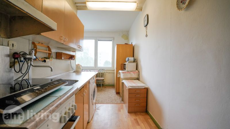 Kuchyně v 2-pokojovém bytě s podlahou s dřevěným dekorem a základním vybavením.