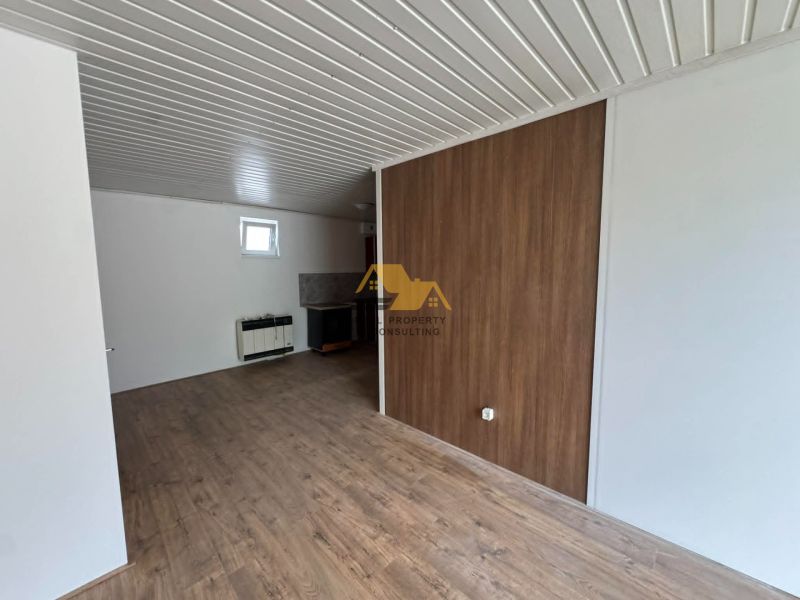 2-pokojový byt s podlahou s dřevěným dekorem a bílými stěnami.