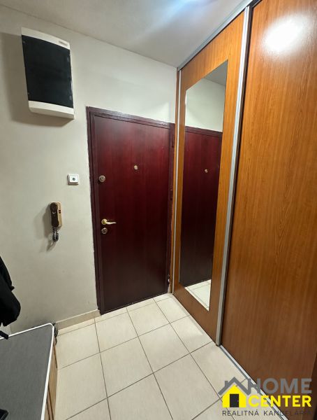 Vstupní předsíň v 3-pokojovém bytě se zrcadlovou šatní skříní a světlou dlažbou.