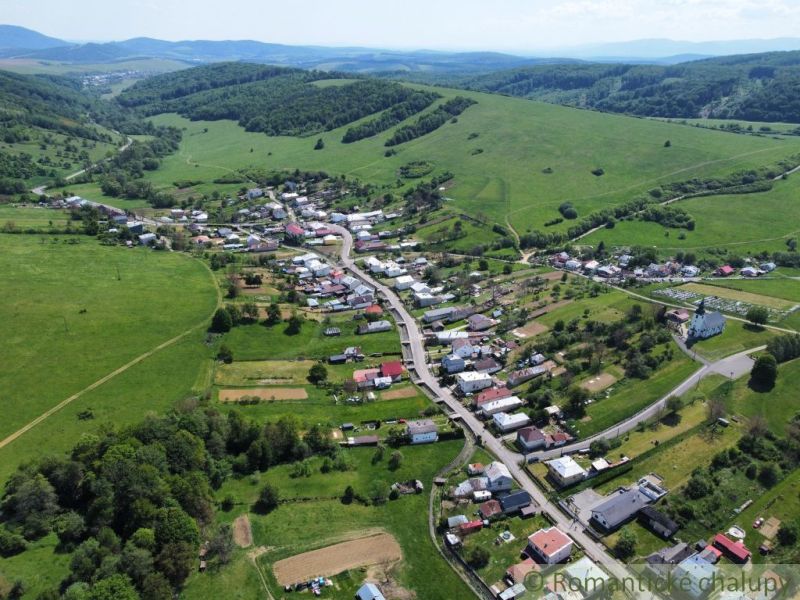 Letecký pohled na obec Karná obklopenou kopci a pozemky k bydlení.
