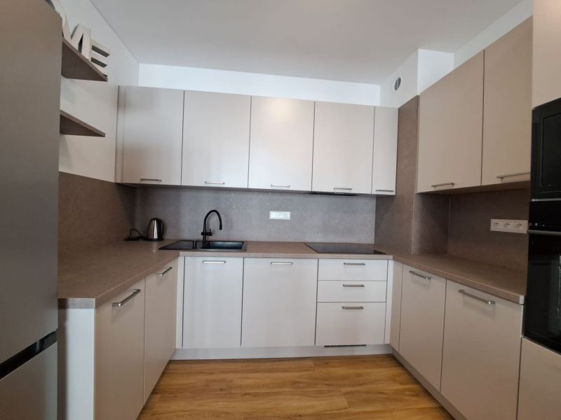 Kuchyně v 2-pokojovém bytě s podlahou s dřevěným dekorem a elegantním nábytkem.