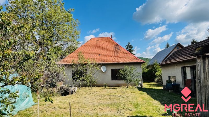 Rodinný dům v Pažiti s červenou střechou na upravené zahradě.