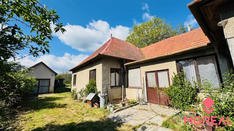 Rodinný dům v Pažiti s červenou střechou a průchodem do zahrady.