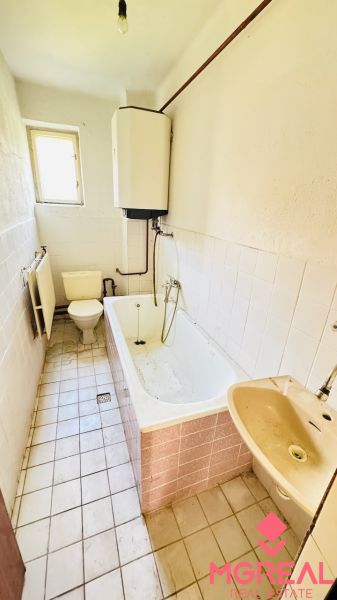 Koupelna v rodinném domě s vanou, umyvadlem a toaletou.