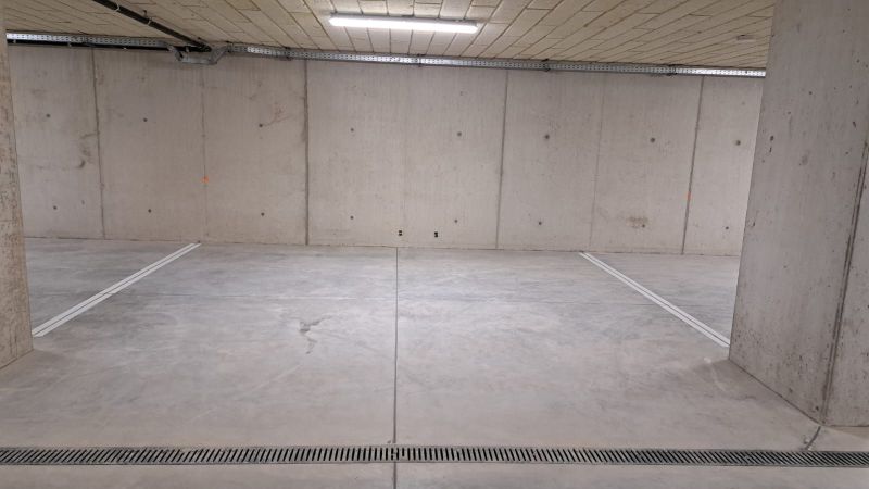 Podzemní garáž s betonovou podlahou a osvětlením.