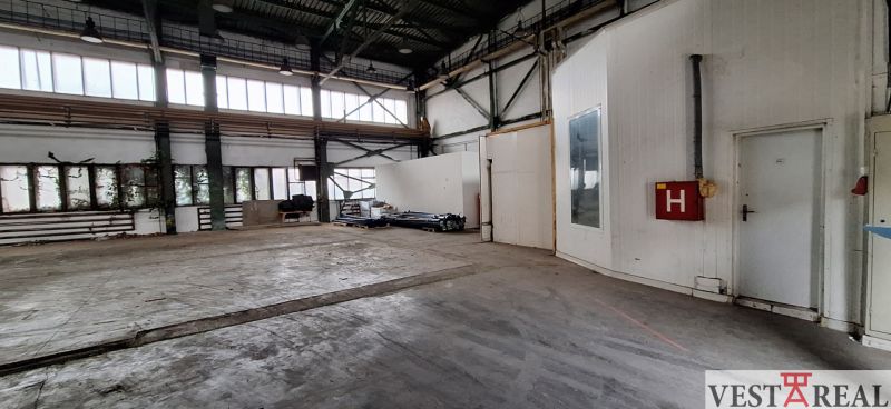 Interiéry skladů a hal se staršími dveřmi a prosklenými okny, industriální prostor.