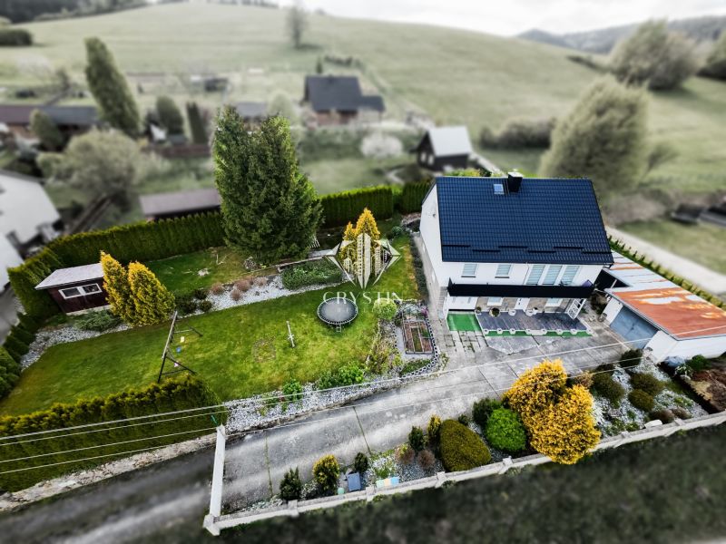 Rodinný dům v Makově s rozlehlou zahradou a stromy, z ptačí perspektivy.