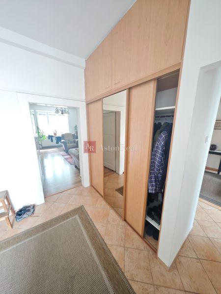 Vestavěná skříň a dlažba v předsíni 2pokojového bytu s podlahou s dřevěným dekorem.