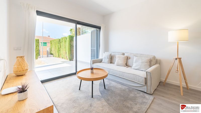 Rekreační apartmán s pohodlnou pohovkou, stolkem a velkým oknem.