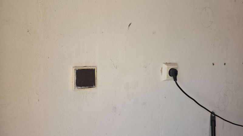Stěna s elektrickou zásuvkou v garážích na Jesenského ulici ve Zvolenu.