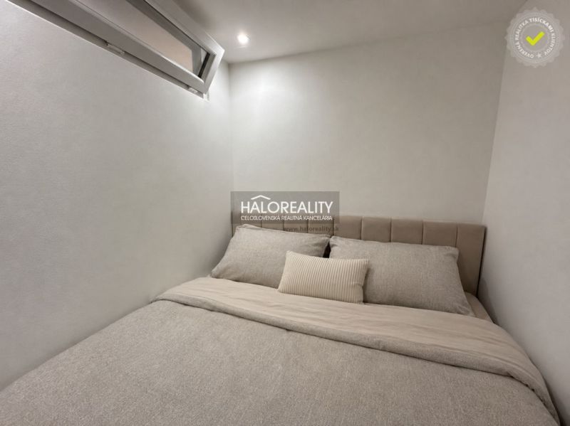 Hostinský pokoj v jednopokojovém bytě s minimalistickým designem a pohodlným lůžkem.
