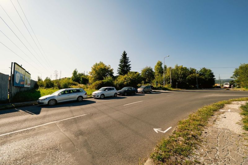 Silnice s parkujícími auty a billboardem na Partizánské cestě, Banská Bystrica, Pozemky - bydlení.