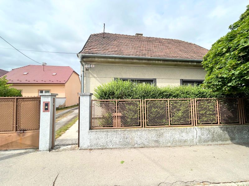Rodinný dům na Krajinské ulici v Bratislavě - Podunajských Biskupicích s plotem a předzahrádkou.