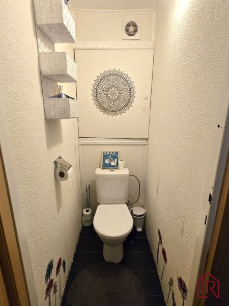 Toaleta se vzorovanou mandalou a úložnými koši ve 4pokojovém bytě.