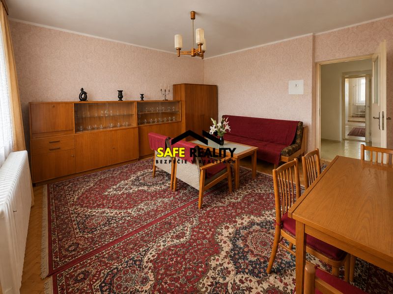 Obývací pokoj v rodinném domě s dřevěným dekorem, retro nábytkem a orientálním kobercem.