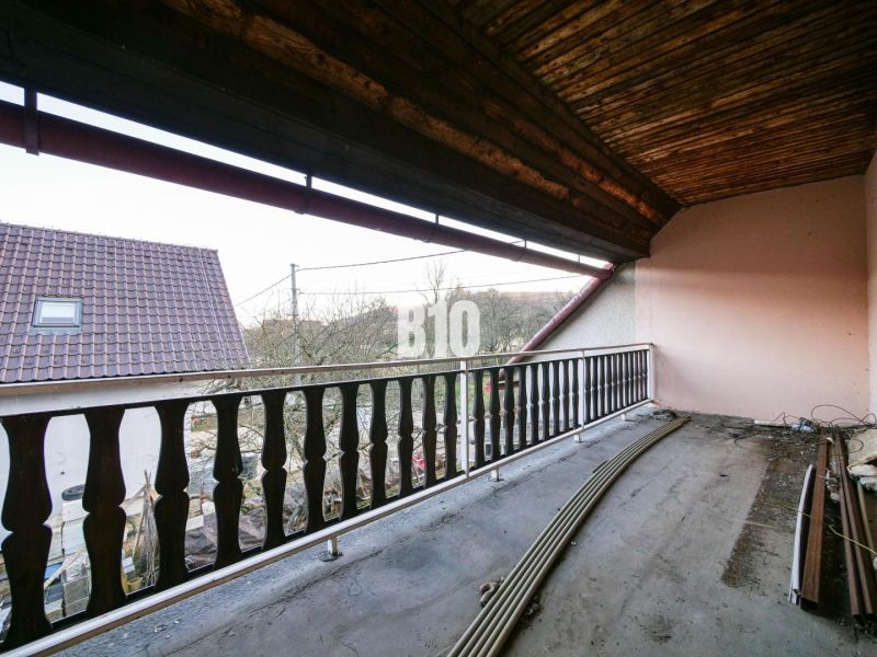 Balkon rodinného domu v Trenčianských Teplicích s výhledem na střechy a přírodu.